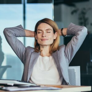 Entspannte Geschäftsfrau mit hinter dem Kopf verschränkten Armen