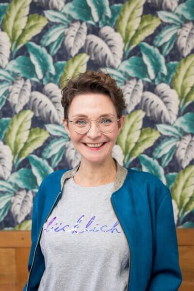 Simone von Yoga40Up strahlt in die Kamera und freut sich, Frauen in der Lebensmitte mit Yoga für die Wechseljahre zu unterstützen.