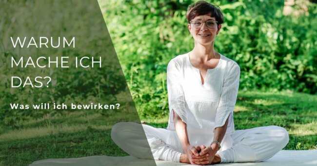 Was will ich bewirken? Simone trägt weiße Kleidung, sitzt auf ihrer Yogamatte in grüner Natur in der Schmetterlingspose.